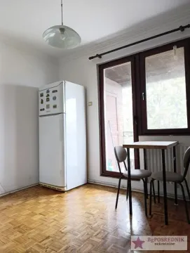 Manja kuhinja sa frižiderom i trpezarijskim stolom pored izlaza na terasu. - image 6
