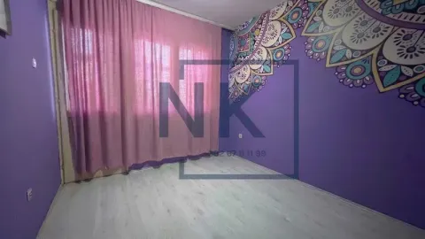 Prazna soba sa ljubičastim zidovima i dekorativnim motivom na jednom zidu. - image 7