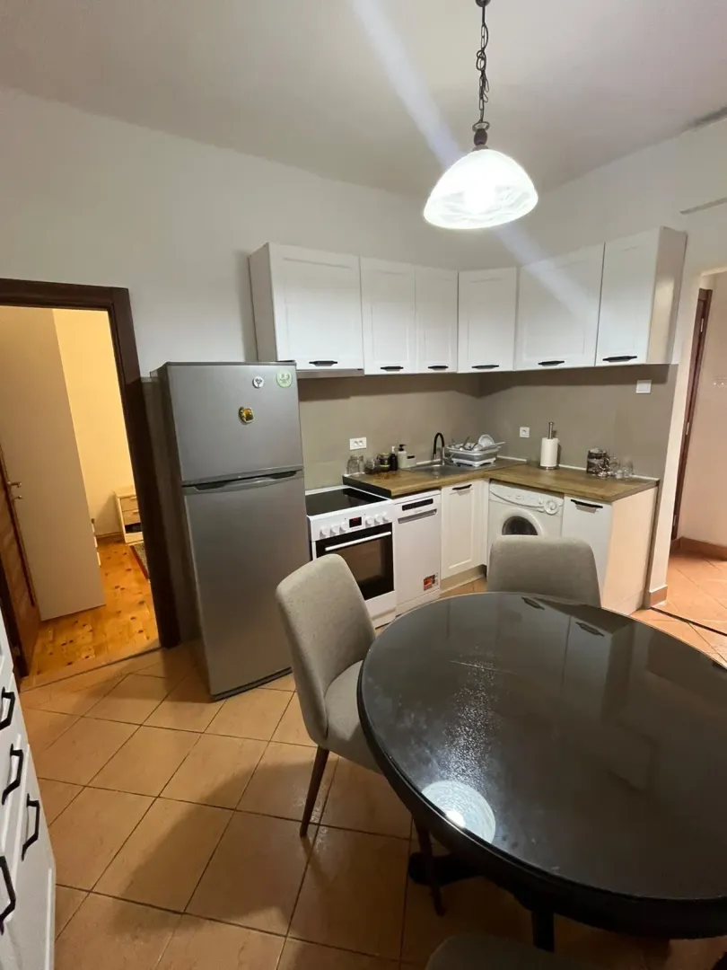 Kitchen with white cabinetry, dining table, and chairs.