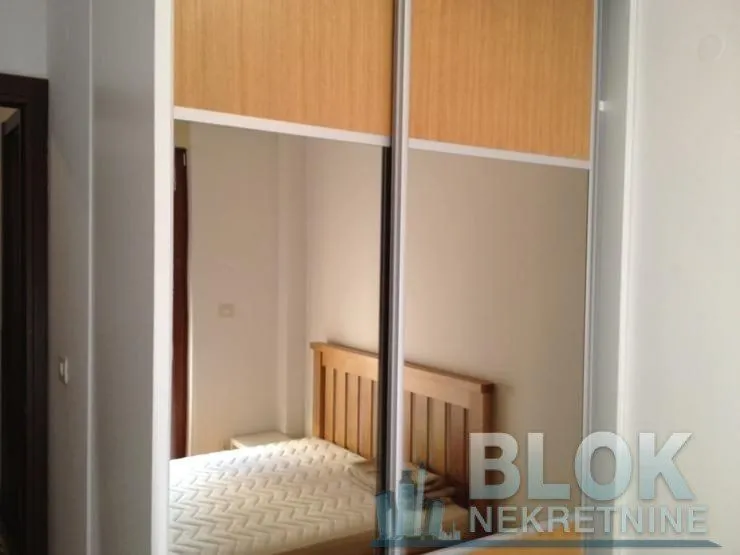 View of the bedroom with a wardrobe and bed in the mirror.