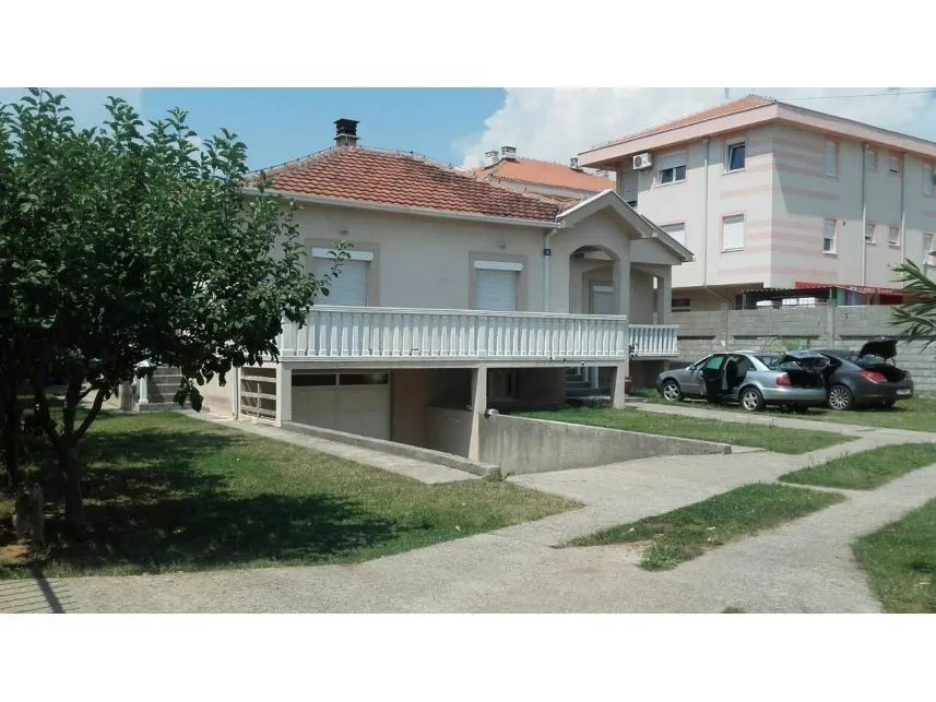 Spoljašnjost jednospratne kuće sa dvorištem i prilazom za garažu.