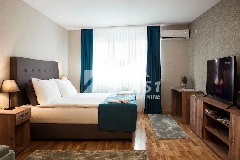 Spavaća soba sa bračnim krevetom, TV-om i klima uređajem.