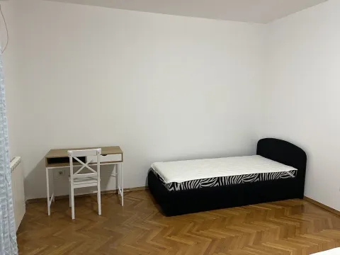 Jednostavno namještena spavaća soba sa jednim krevetom i radnim stolom. - image 20