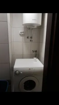 A bathroom corner with a washing machine and a water heater. - image 3