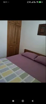 Bedroom with a double bed and wooden wardrobe. - image 5