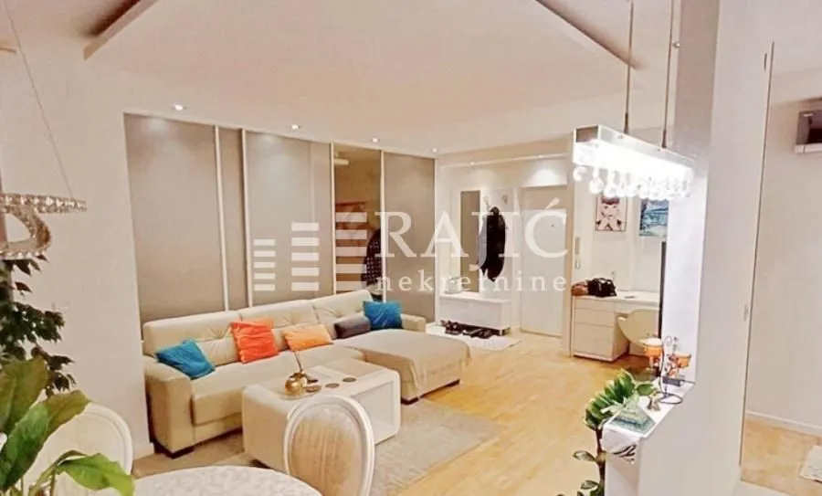 Spacious living room with sofa and dining area.
