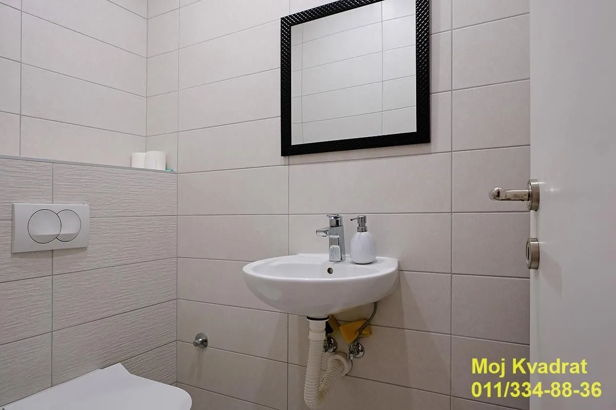 Manje kupatilo sa umivaonikom, ogledalom i WC šoljom.