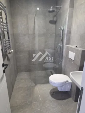 Modern bathroom with a walk-in shower lined with grey tiles. - image 9