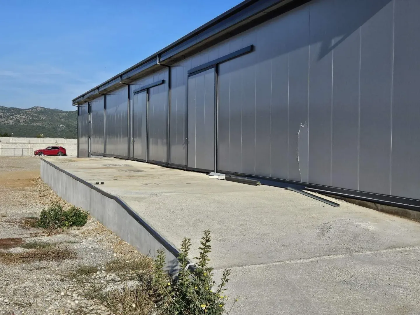Exterior of an industrial building with a concrete ramp.