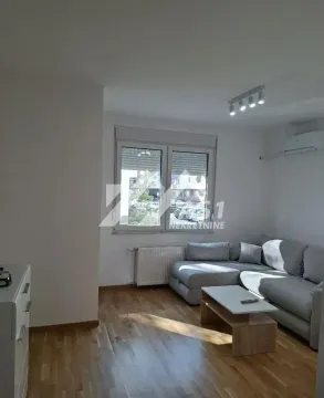 Dnevna soba sa ugaonom garniturom, stočićem i prozorom koji gleda na spoljašnjost. - image 4