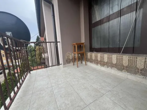 Small tiled balcony with a metal railing and a wooden stool. - image 14