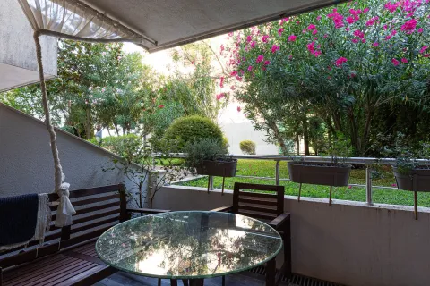 Natkrivena terasa sa drvenom garniturom za sjedenje i pogledom na zeleno dvorište. - image 18