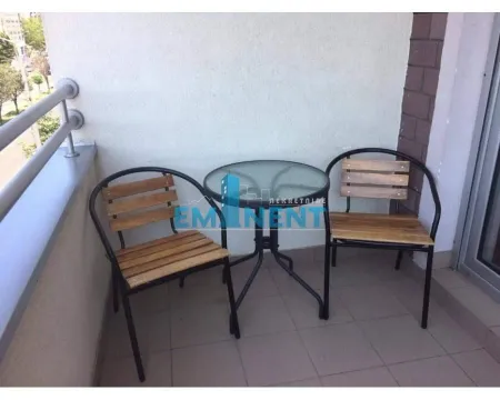 Small furnished balcony with a glass table and two chairs. - image 13