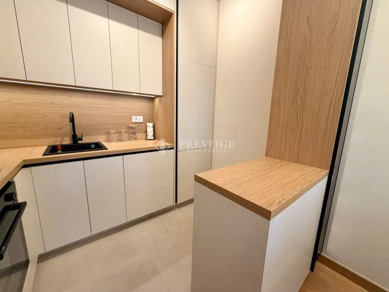 Moderna kuhinja sa ugradnim elementima i šankom.