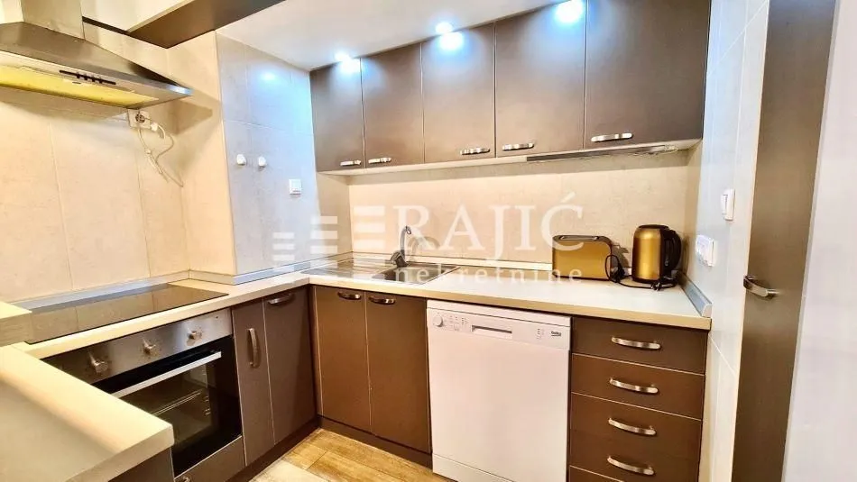 Modern kitchen with brown cabinetry and built-in appliances.