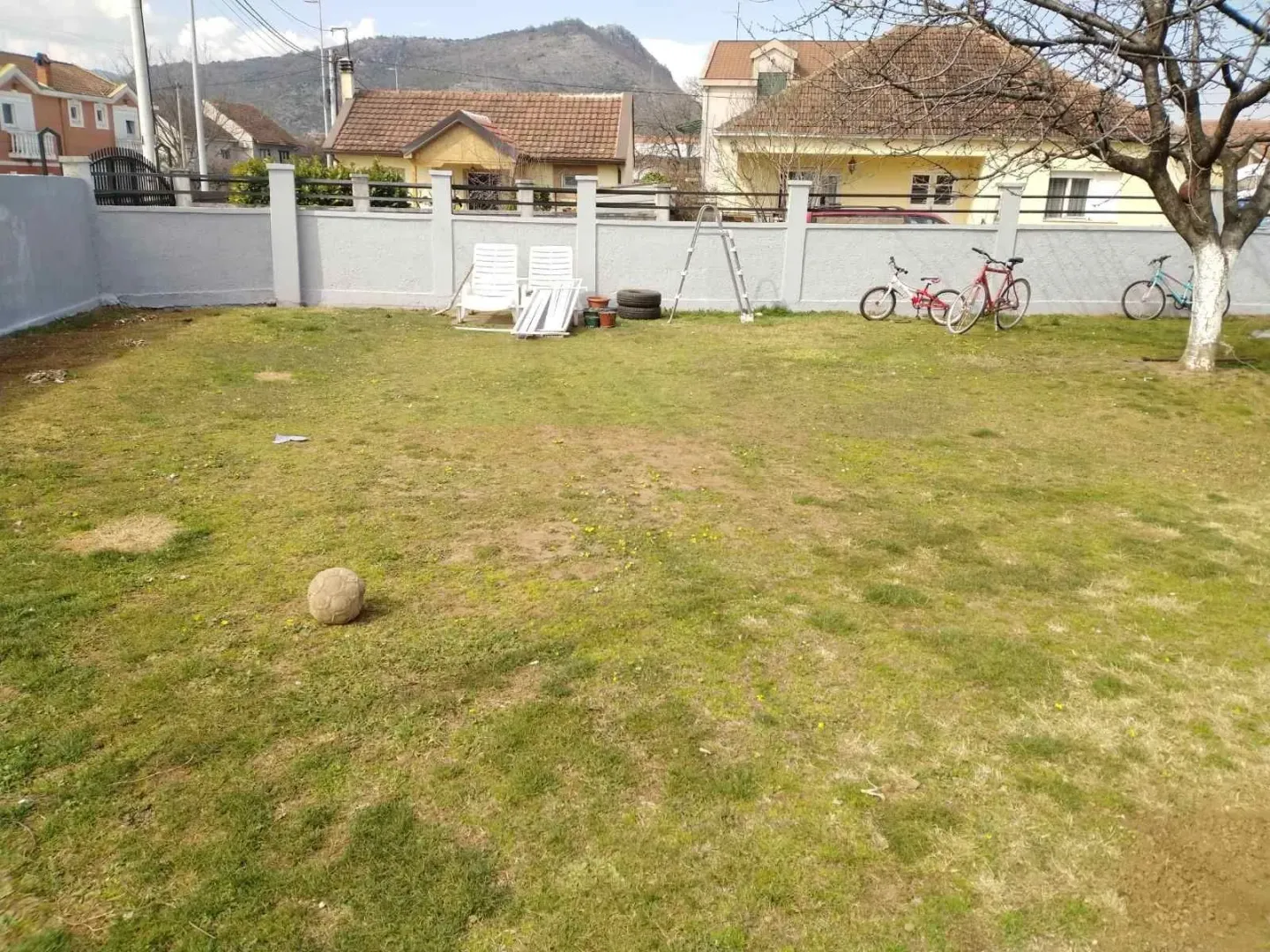 A spacious fenced yard with a lawn area.