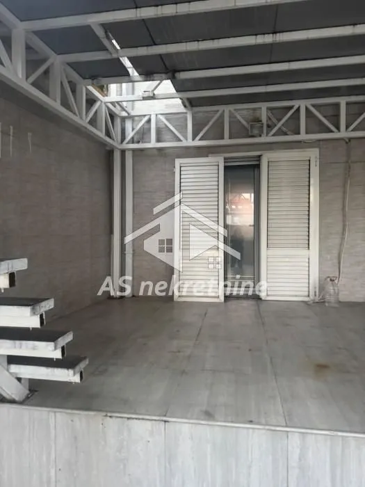Covered terrace with tiled flooring and a staircase.