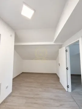 Empty room with laminate flooring and white walls in the attic. - image 7