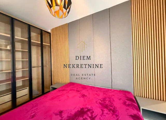 Modern bedroom with a double bed, large wardrobe, and wooden wall panels.