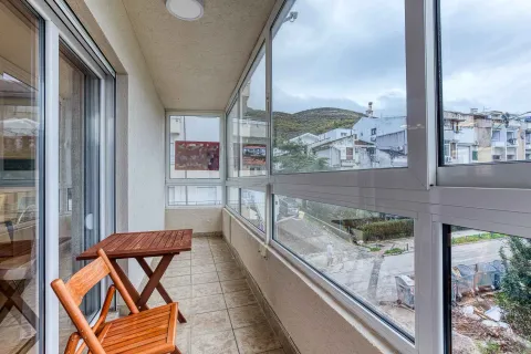 Glazed balcony with a wooden table and chairs and a view of the surroundings. - image 10