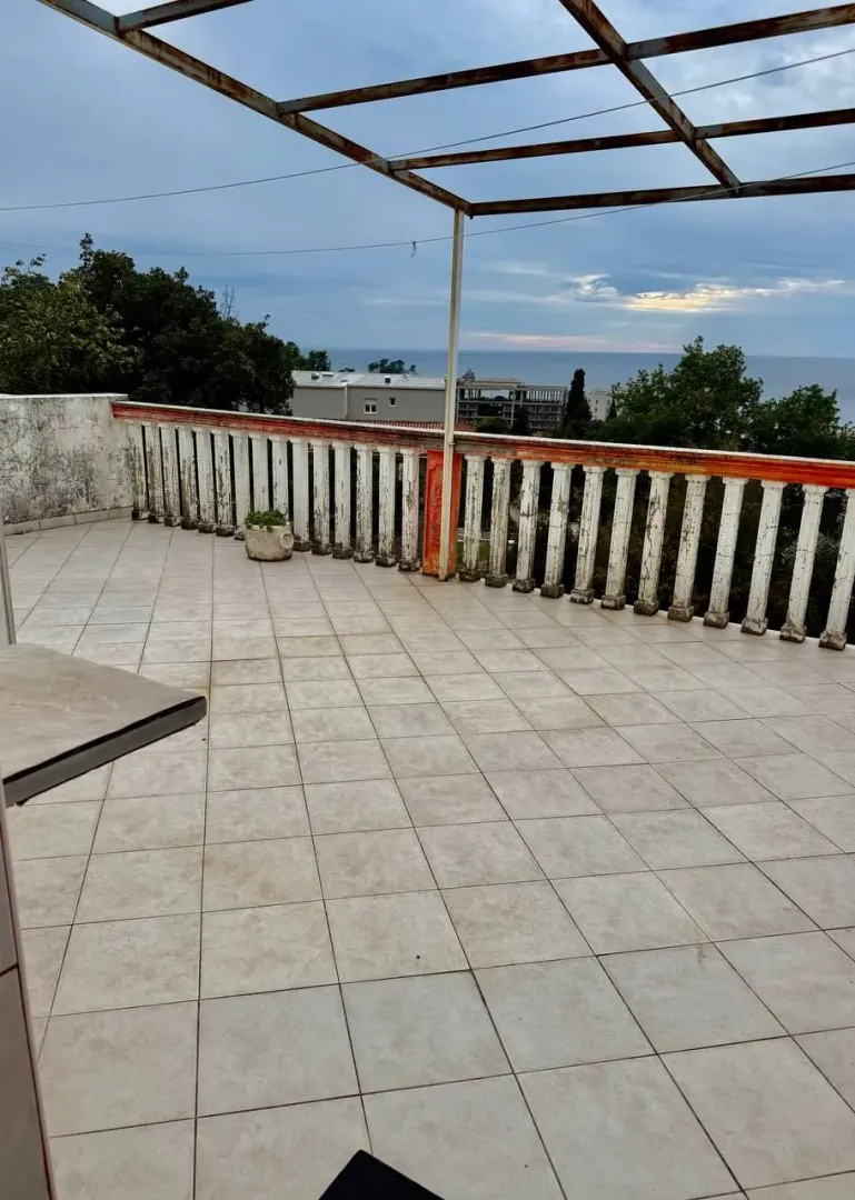 Prostrana popločana terasa sa pogledom na more.