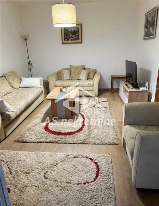Living room with seating furniture, coffee table and television.