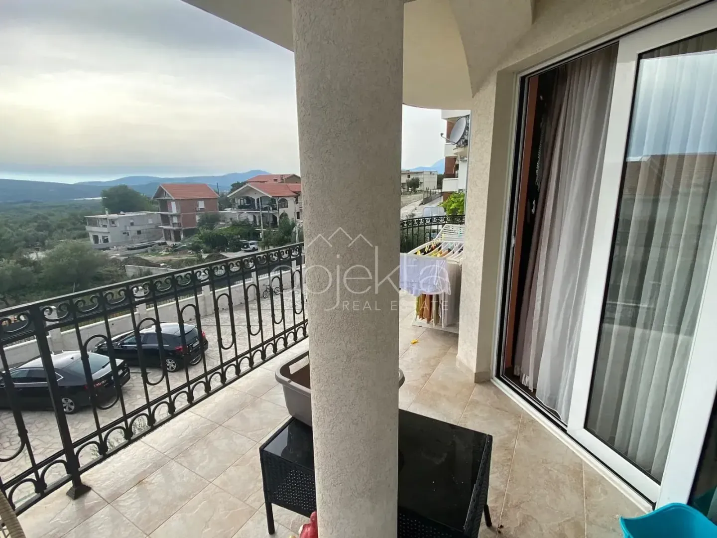 Spacious terrace with a view of the surroundings and parked vehicles.
