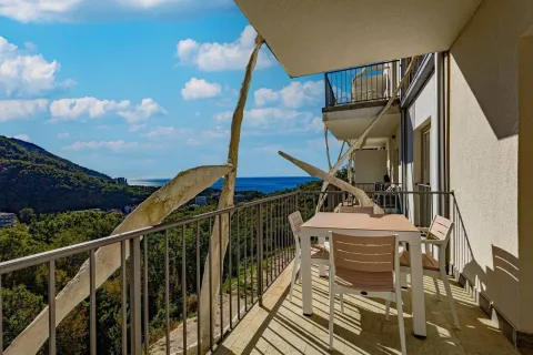 Spacious balcony with a table, chairs, and a sea view. - image 3