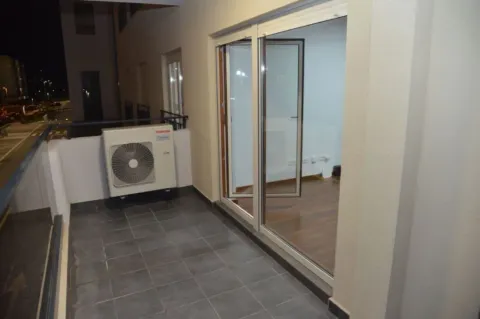 A balcony with an air conditioning unit and large glass doors. - image 7
