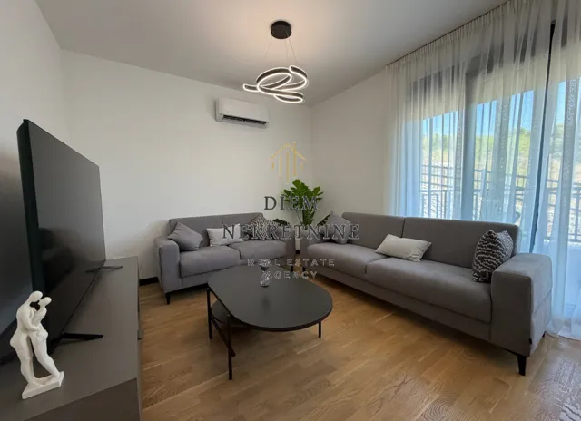 Modern and bright living room with a sofa set and a TV.
