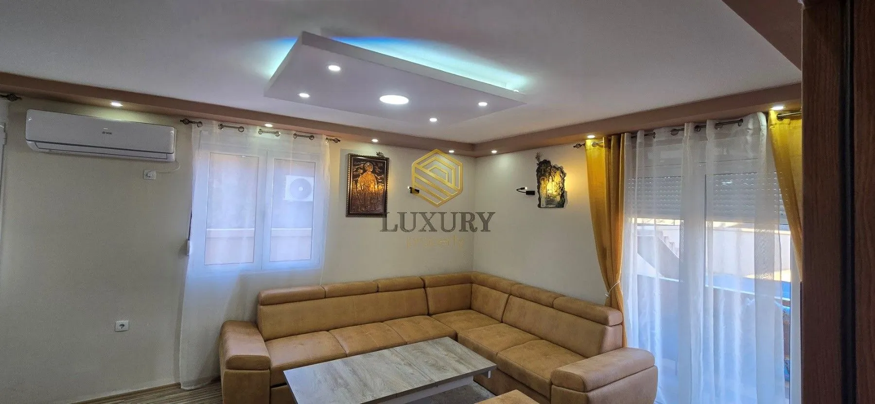 Corner sofa in the living room with a drop ceiling and lighting.