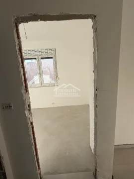 Pogled kroz otvoren prolaz na nameštenu prostoriju sa prozorom. - image 11