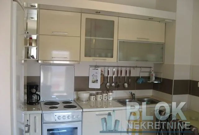 Smaller kitchen with cream-colored cabinetry, a stove, and a sink.