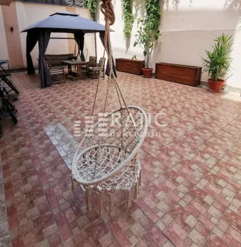 Popločano dvorište sa garniturom za sedenje i visećom stolicom. - image 8