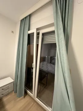 Balcony doors with light blue curtains in a bedroom. - image 7