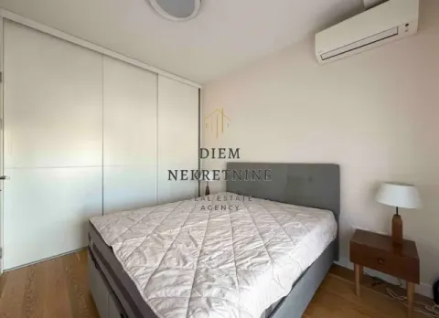 Furnished bedroom with a double bed, wardrobe, and air conditioning. - image 11