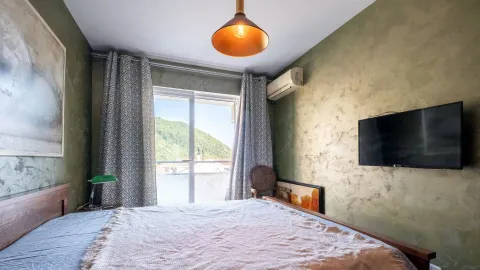 Namještena spavaća soba sa bračnim krevetom, televizorom i izlazom na terasu. - image 6