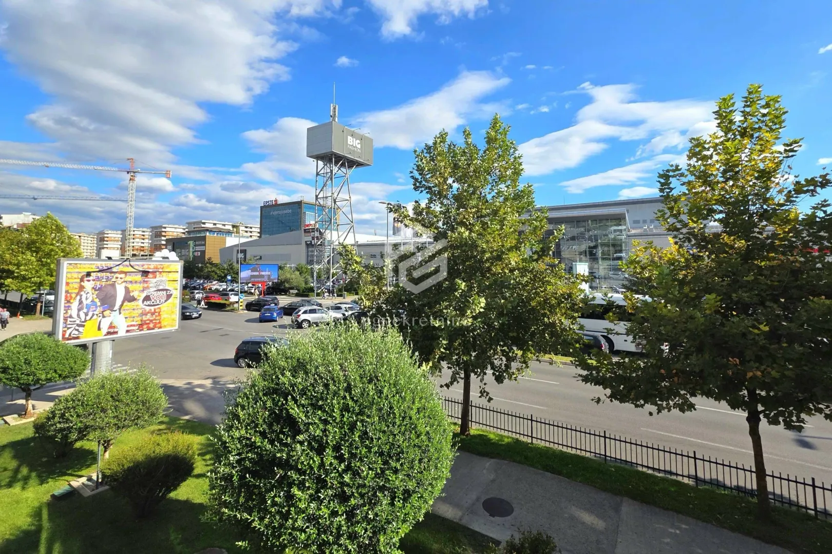 View from the window overlooking surrounding streets, greenery, and commercial buildings.