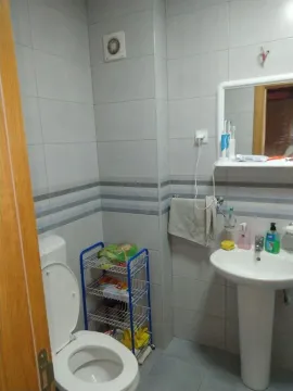 Small bathroom with a washbasin, toilet bowl and wall tiles. - image 2