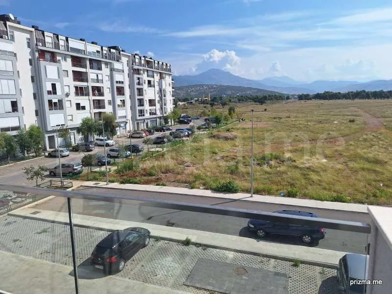 View from the terrace overlooking the building, parking lot, and surrounding landscape.