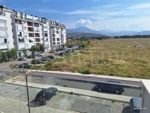 View from the terrace overlooking the building, parking lot, and surrounding landscape. - image 8