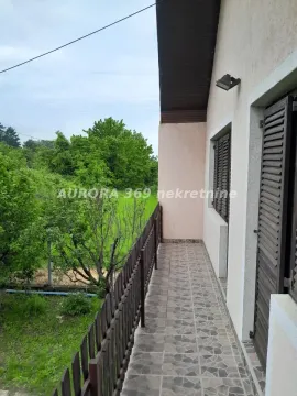 Natkriveni balkon sa popločanim podom i pogledom na zelenilo i dvorište. - image 6