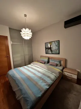 Bright bedroom with a double bed, nightstand, and built-in wardrobe. - image 5