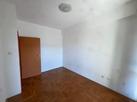 Empty room with parquet flooring and a wooden door. - image 7