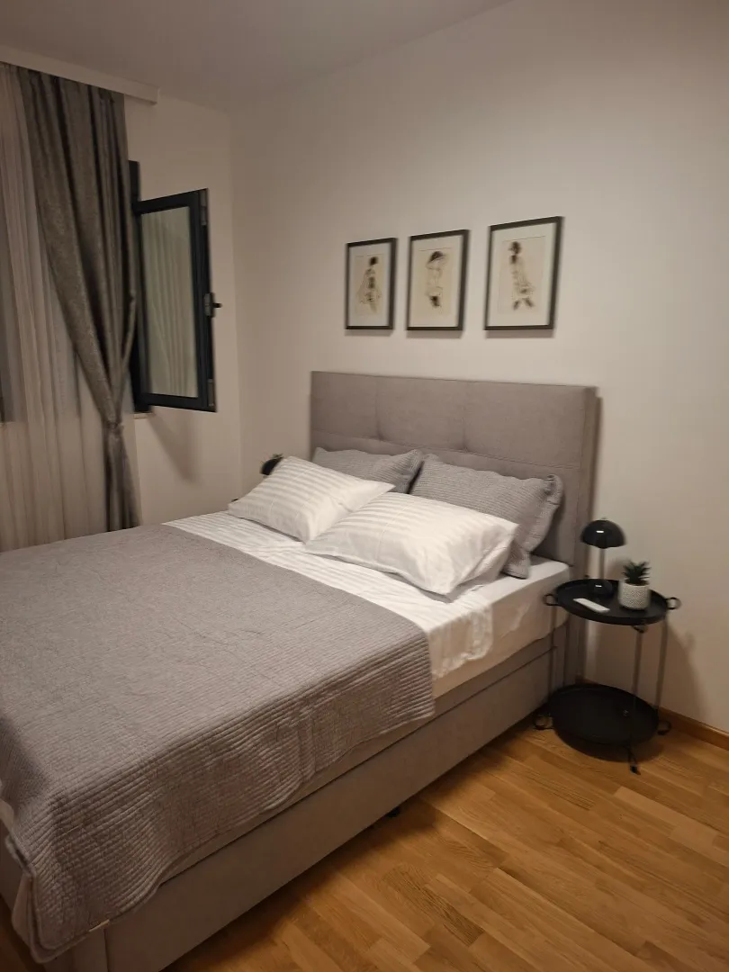 A furnished bedroom with a double bed and pictures on the wall.