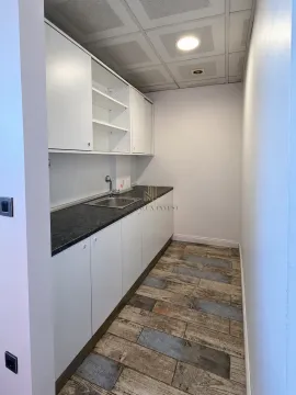 Small kitchenette with white units and a sink. - image 18