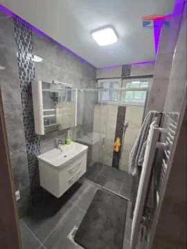 Modern bathroom with a walk-in shower, vanity, and recessed lighting. - image 4
