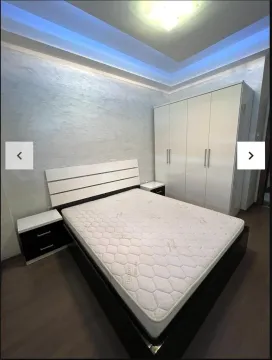 Furnished bedroom with a double bed and a large wardrobe. - image 5