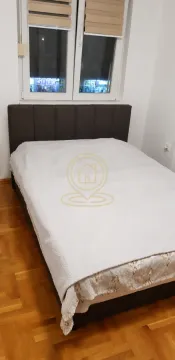 Bračni krevet u spavaćoj sobi sa parketom na podu i prozorom u pozadini. - image 6