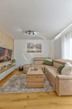 Dnevna soba sa ugaonom garniturom, televizorom i drvenim podom. - image 5